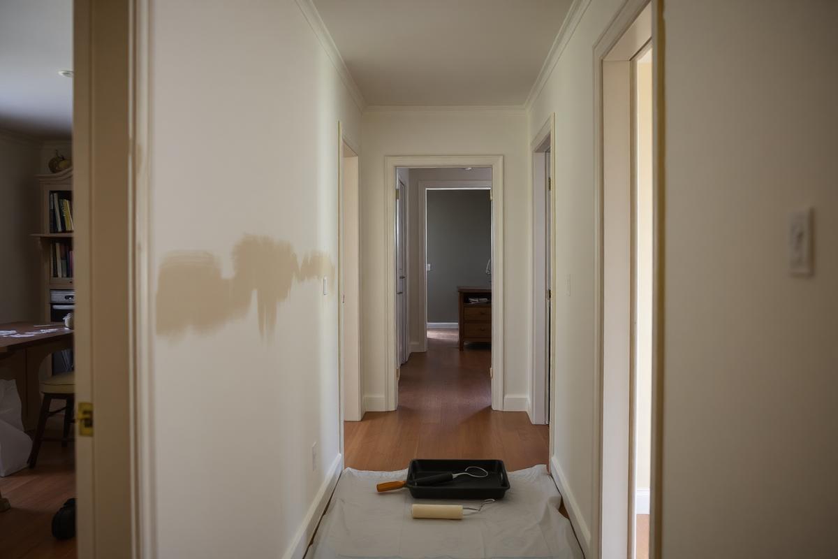 Hallway in a family home with fresh paint and a roller tray on a drop cloth
